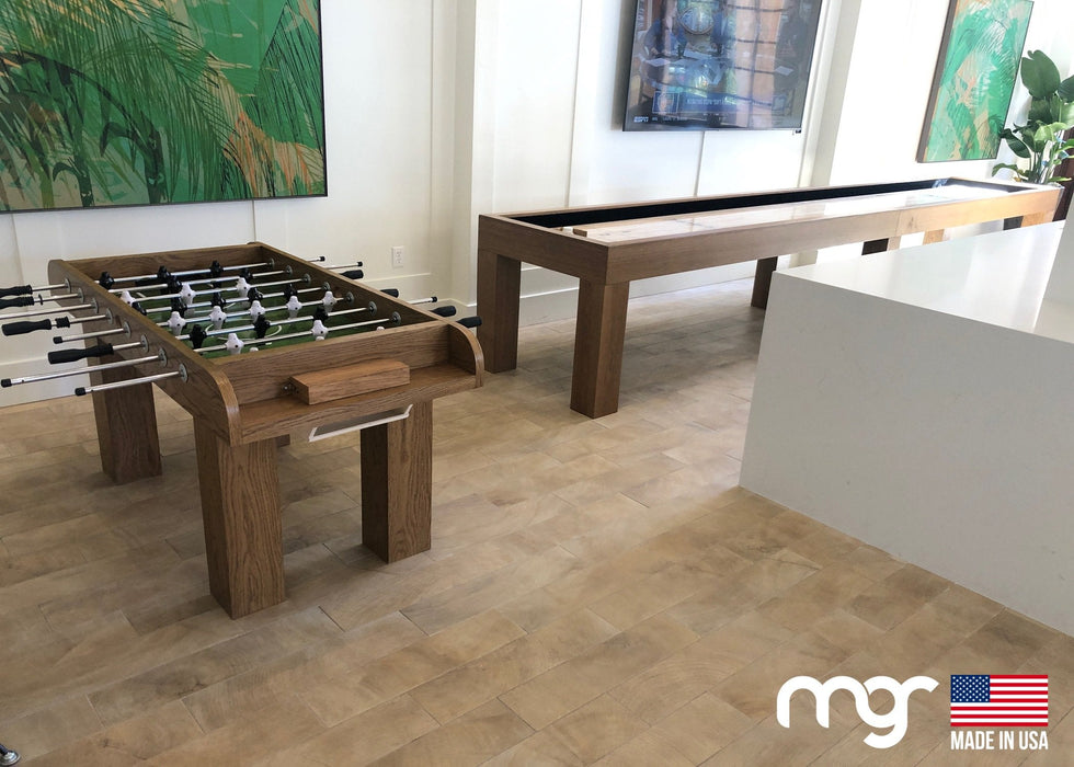 Wooden foosball and pool tables in a room with modern decor.