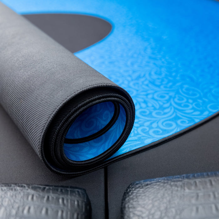 Roll of gray yoga mat on a blue and black patterned surface