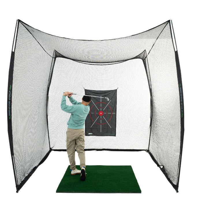 Person practicing golf swings in a netted hitting cage with a target board.