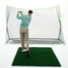 Person practicing golf swings on a mat with a net in the background