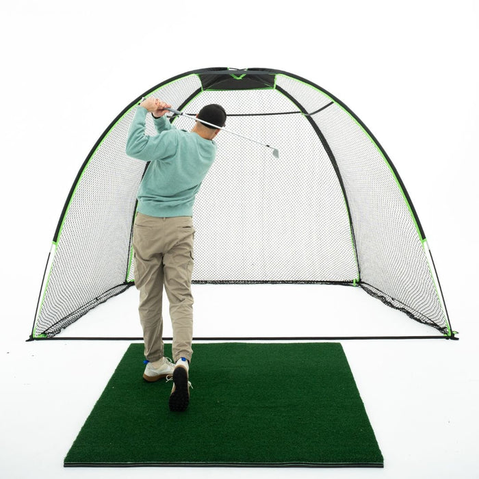Person practicing golf swings inside a portable hitting cage on a green mat.