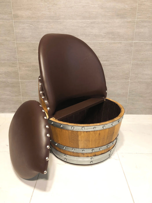Chair made from a wooden barrel with brown leather seats on a tiled floor.
