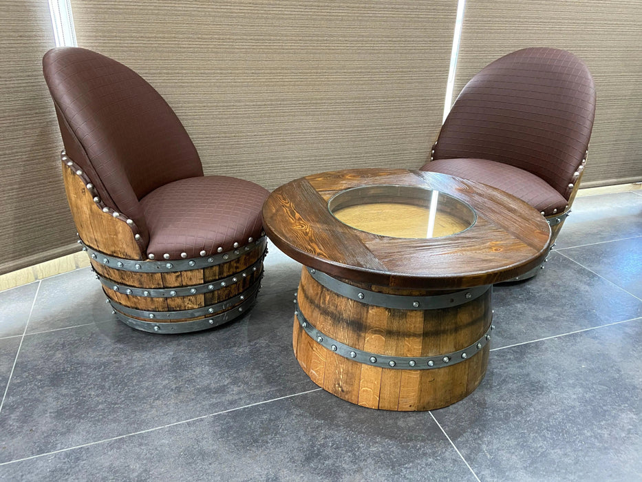 Two barrel chairs with a barrel table on a tiled floor.