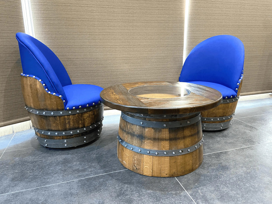 Wooden barrel-style table with two matching chairs featuring blue cushioned seats on a tiled floor.
