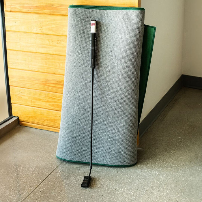 Roll of gray felt with a green edge on a concrete floor.