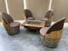 Wooden barrel chairs with a matching table on a tiled floor.