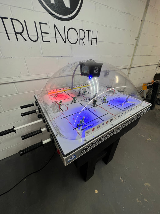 Hockey table with illuminated rink and 'True North' branding on the wall.