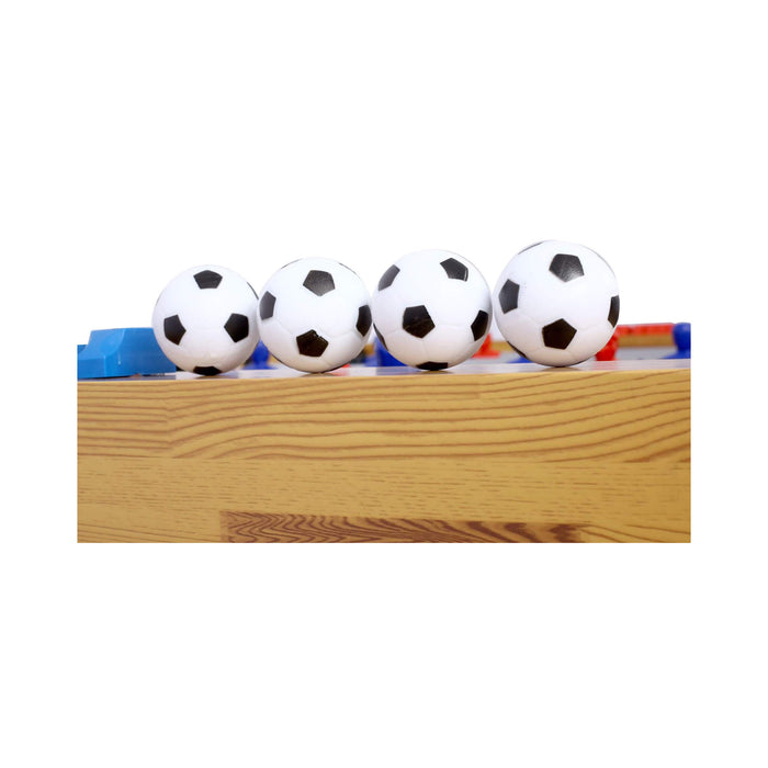 Four soccer-themed table tennis balls on a wooden table with blue and red edges.