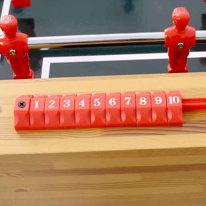 Red foosball table with numbered red rods on a wooden surface