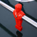 Red foosball player on a black table