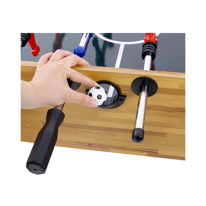 Hand interacting with a table football piece on a wooden surface