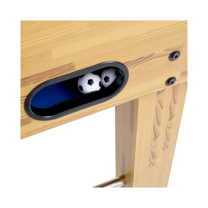Wooden table with a small oval hole revealing two soccer balls inside.