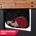 Black mesh storage pocket attached to a wooden bench with red and white ping pong balls inside, labeled 'BUILT-IN STORAGE SPACE'.