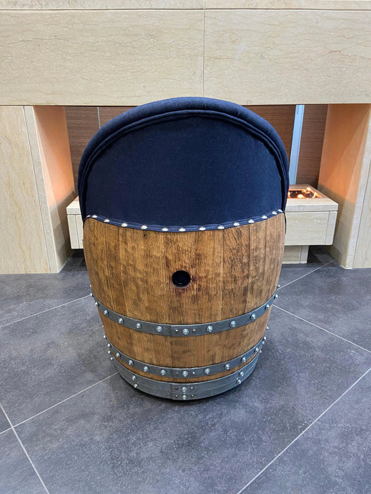 Wooden barrel with a blue cushion on a tiled floor
