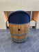 Wooden barrel with a blue cushion on a tiled floor