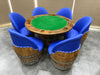 Poker table with green felt surface surrounded by blue chairs on a tiled floor.