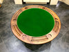 Round green table with wooden border on a tiled floor