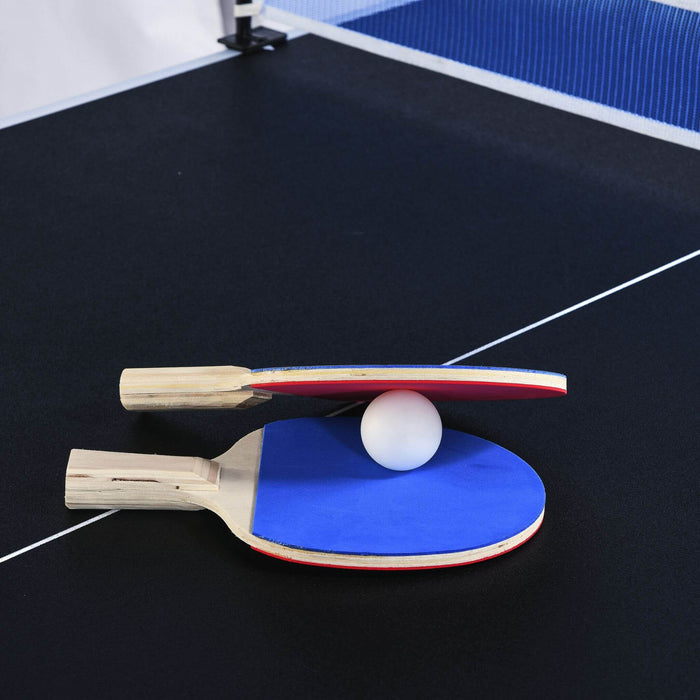 Two ping pong paddles and a ball on a black table with blue edges.