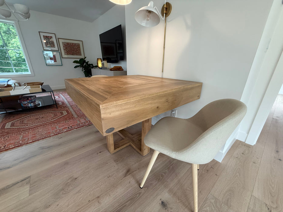 Wooden dining table with a chair in a living room setting