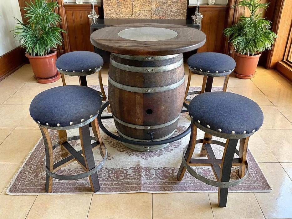 Bar setup with a barrel table and stools in a room with plants and wooden furniture.