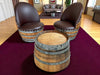 Wooden barrel chairs with brown leather seats in a room setting.