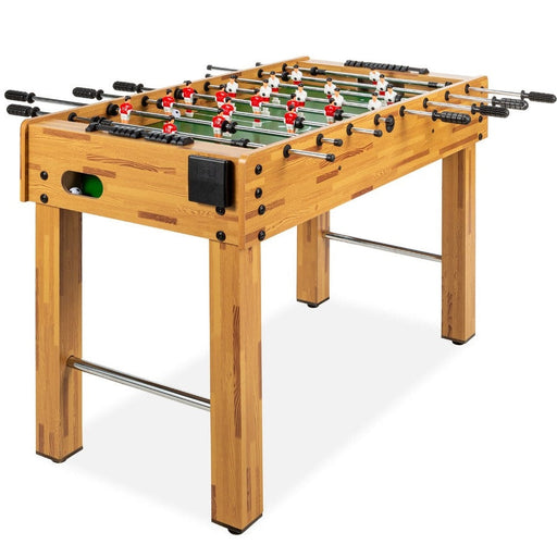 Wooden foosball table with green playing surface and red and white player figures on a white background