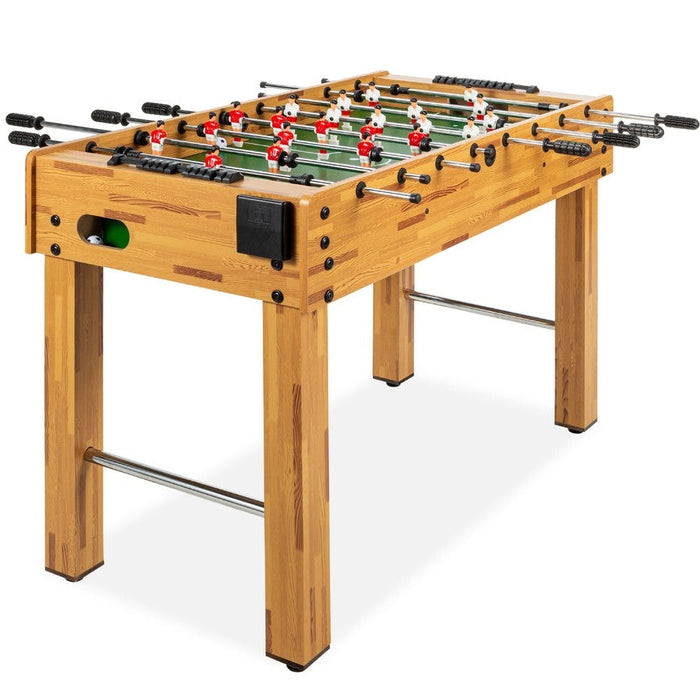 Wooden foosball table with green playing surface and red and white player figures on a white background