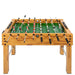 Foosball table with wooden frame and green playing surface on a white background
