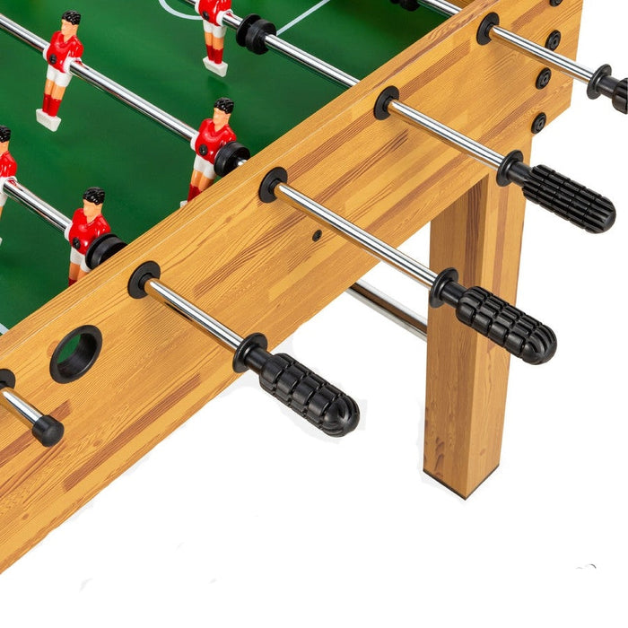 Close-up of a foosball table with players on the green playing surface.