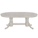 Round white dining table with pedestal legs on a white background