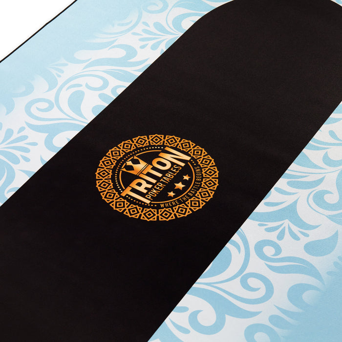 Black skateboard deck with gold logo on a blue and white patterned background