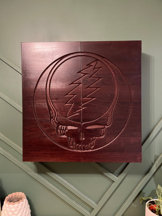 Wooden plaque with Grateful Dead logo on a wall.
