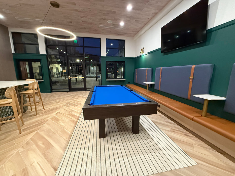 Game room with pool table, seating area, and television.