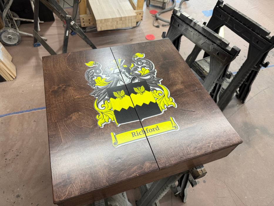 Wooden table with a family crest and name on a workshop floor