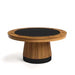 Round wooden table with a black circular top on a white background