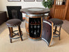Wine barrel table with wine bottles and glasses in a home setting