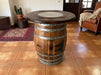 Wooden barrel table in a room with a rug and chair.