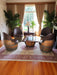 Living room with barrel chairs and a table in front of a large window.