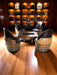 Wooden barrel chairs around a table in a room with bookshelves.