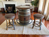 Wooden barrel table with two stools in a living room setting