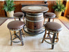Barrel table with four stools in a room with wooden paneling and plants.