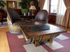 Wooden barrel chairs and table in a room with plants and decor.