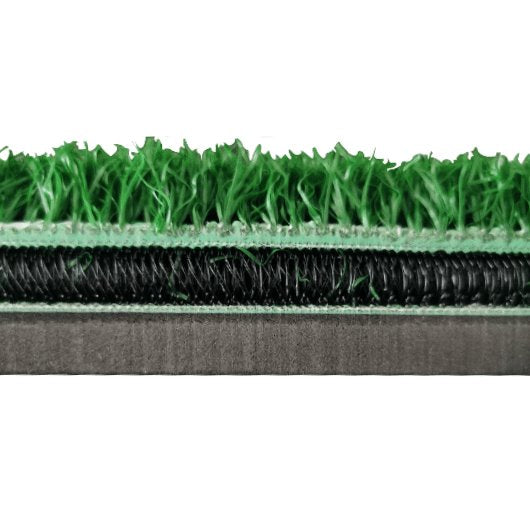 Cross-section of artificial grass with green top layer, black coil, and gray base on a white background