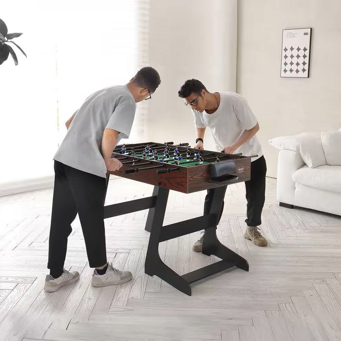 Two men playing foosball in a modern living room.