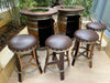 Bar set made from wine barrels with stools on a wooden deck.