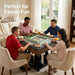 Four people playing a board game together in a cozy living room.
