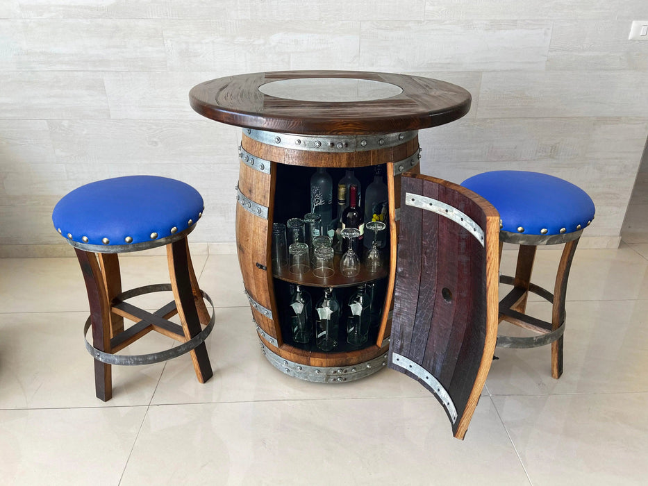 Wooden barrel bar with glassware and two blue cushioned stools.