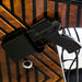 Black gun with a magazine on a reflective surface with a blurred background