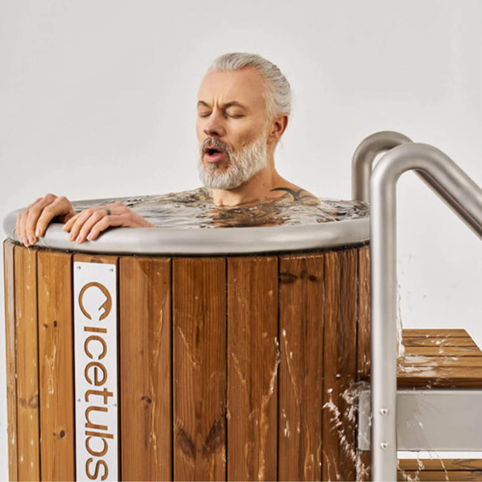 Man with eyes closed leaning over a wooden hot tub with 'Cicetubs' branding.