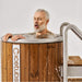 Man with eyes closed leaning over a wooden hot tub with 'Cicetubs' branding.